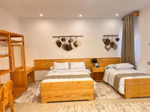 two beds in a room with hats on the wall at deluxe experience siwa in Siwa