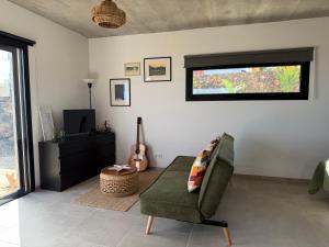 a living room with a chair and a television at Casa Bela in Villaverde