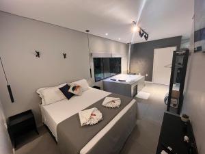 a bedroom with a large white bed and a sink at RASTRO Cabins in Restinga Sêca