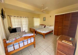a living room with two beds and a tv at Dennis' Hideaway in Mayreau