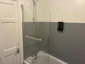 a shower with a glass door next to a bath tub at Flat in Pont y Rhyl in Pont y Cymmer +31 photos
