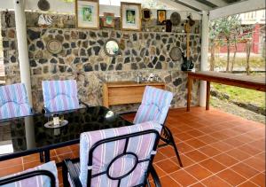 a room with a table and chairs and a stone wall at Dennis' Hideaway in Mayreau