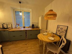 a kitchen with a wooden table and a dining room at The Nest, Apartament in Oświęcim