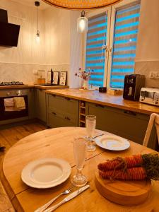 a wooden table with plates and glasses on top of it at The Nest, Apartament in Oświęcim +20 photos