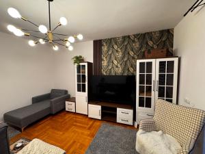 a living room with a couch and a flat screen tv at The Nest, Apartament in Oświęcim