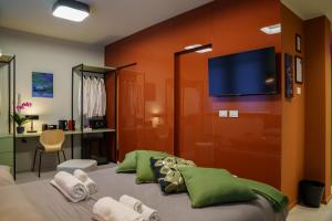 a bedroom with a bed with a flat screen tv on the wall at JDN Rooms in San Donato Milanese