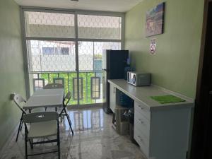 a kitchen with a counter and a table with a microwave at CASA DE LA ABUELa in Colima