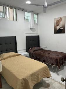 a bedroom with two beds and a painting on the wall at CASA DE LA ABUELa in Colima