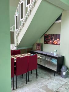 a dining room with a table and red chairs at CASA DE LA ABUELa in Colima