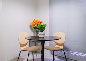 a table with four chairs and a vase with flowers on it at JDN Rooms in San Donato Milanese