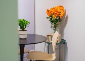 a table and two chairs and a vase of flowers at JDN Rooms in San Donato Milanese +52 photos