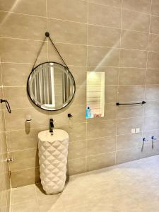 a bathroom with a round mirror on the wall at شاليهات سمو بارك 2 in Taif +17 photos