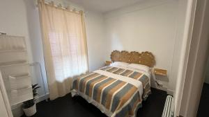a bedroom with a bed with a striped blanket and a window at HT MIRIBILLA habitaciones turísticas sin ascensor in Bilbao +23 photos