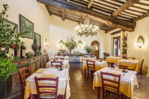 restauracja ze stołami i krzesłami oraz żyrandolem w obiekcie Villa Le Barone w mieście Panzano in Chianti
