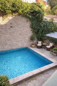 a blue swimming pool next to a brick wall at Wisby Residence in Visby