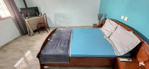 a bedroom with a bed with a blue wall at Chez Rossa à Deido in Douala