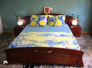a bedroom with a bed with a blue and yellow comforter at Chez Rossa à Deido in Douala +10 photos