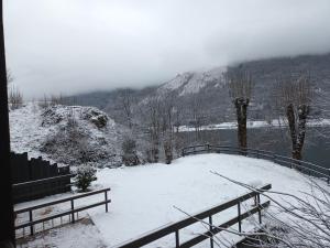 a snow covered area with a view of a mountain at Maison dans un chalet en bordure de lac in Loudenvielle