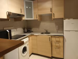 a kitchen with a white refrigerator and a dishwasher at Maison dans un chalet en bordure de lac in Loudenvielle +8 photos