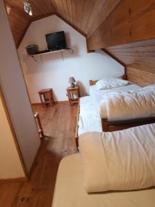 a attic room with two beds and a tv at Maison dans un chalet en bordure de lac in Loudenvielle