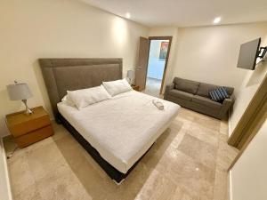 ein Schlafzimmer mit einem großen Bett und einer Couch in der Unterkunft Central 102 Malecón in Mazatlán + 29 Fotos