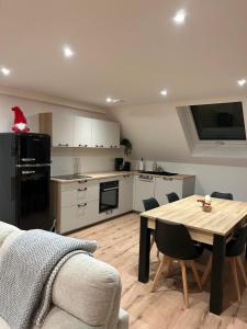 a kitchen with a wooden table and a dining room at La parenthèse in Artolsheim