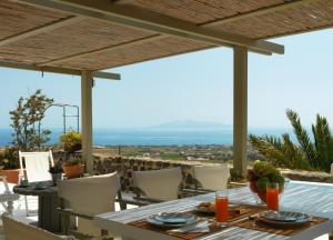 a dining table with a view of the ocean at AFOURA HOUSES by K&K in Pirgos