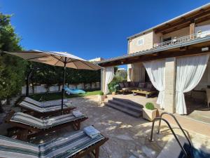 a patio with a table and an umbrella at Villa Susann in Šibenik