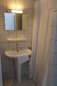 a bathroom with a sink and a mirror and a shower at Hôtel Le Palous in Baraqueville