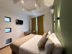 a bedroom with a bed and a desk and a television at Hotel B&B Nativo Peñón in Cali