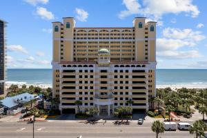 a large hotel with the ocean in the background at Camelot by the Sea Oceanfront 2BR in Myrtle Beach