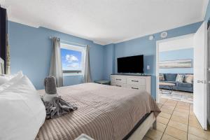 a blue bedroom with a bed and a television at Camelot by the Sea Oceanfront 2BR in Myrtle Beach