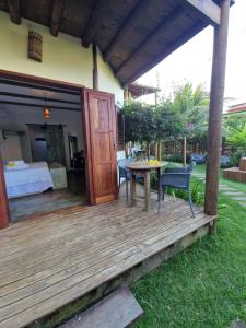 a wooden deck with a bed and a table at Vila Cacau pousada - Serra Grande in Serra Grande