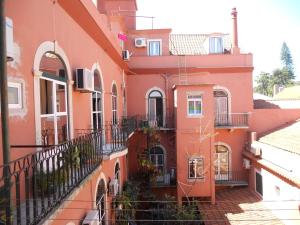 un bâtiment orange avec balcon dans une rue dans l'établissement Hotel Belém Tejo - Setubalense, à Lisbonne