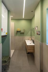a bathroom with a sink and green walls at B&B Sentiero Rusca in Sondrio +32 photos