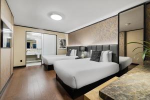 a hotel room with two beds and a bathroom at Hudson Yards Hotel in New York
