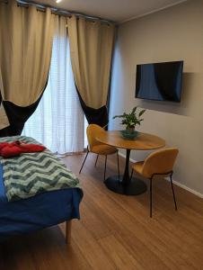 a room with a table and a bed and a tv at B&B Sentiero Rusca in Sondrio