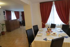 a dining room table with chairs and a tableablish at Vila Piano in Buşteni