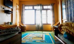 a room with a window and a rug on the floor at Bethany Homestay in Kalimpong