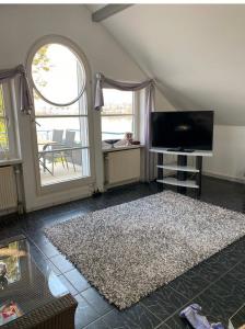 a living room with a flat screen tv and a rug at Viktoria`s Penthouse in Bad Breisig