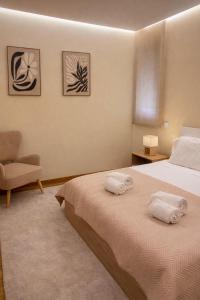a bedroom with a bed and a chair at Almeida's House in Viana do Castelo