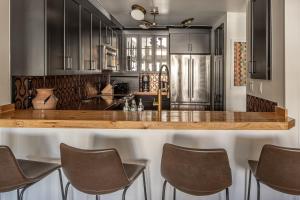 a kitchen with black cabinets and a wooden counter top at North Summit in Big Sky +33 photos
