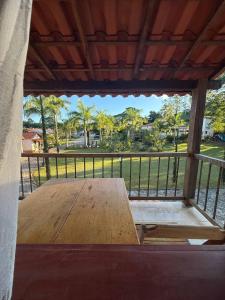 a wooden table on a porch with a view of a park at Pousada Chalés Jatobá in Prados