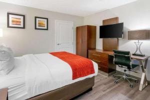 a bedroom with a bed and a desk with a computer at Antioch Inn and Suites in Antioch