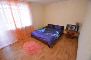 Schlafzimmer mit einem Bett, einem Tisch und einem Fenster in der Unterkunft Apartment on Navarynska in Mykolajiw