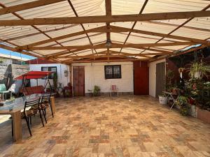 a large patio with a wooden ceiling and tables and chairs at Refugio Costero in Caldera
