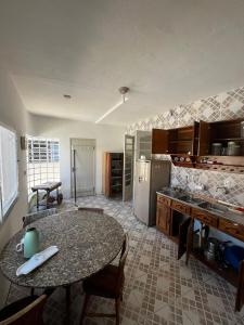 a kitchen with a table and a counter top at Casa Top Laranjal com Piscina in Pelotas