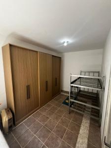 a bedroom with a bunk bed and wooden cabinets at Casa Top Laranjal com Piscina in Pelotas