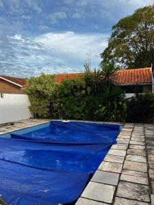a blue swimming pool in a yard with a house at Casa Top Laranjal com Piscina in Pelotas