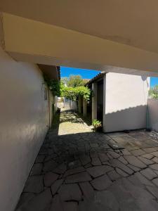 an empty courtyard of a house with a stone walkway at Casa Top Laranjal com Piscina in Pelotas